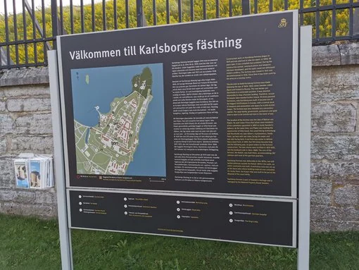 Välkommen till Karlsborgs fästning Informationsskylt vid Karlsborgs fästning med karta och beskrivning av området.
