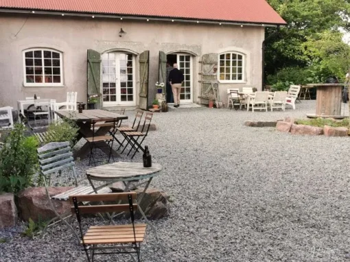Vedens Lustgård utanför Skara med restaurerad lada, uteservering och lantlig miljö där vedugnsbakade pizzor serveras.