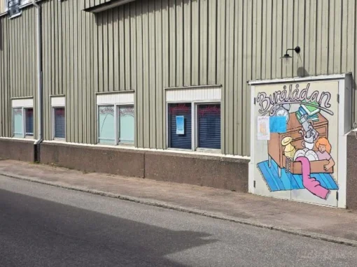 Byrålådan i Falköping, loppis- och antikbutik med skyltad entré och målad dörr på fasaden.